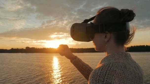 Mujer usando gafas de realidad virtual en la cubierta del crucero al atardecer — Vídeos de Stock