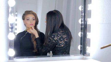 Dudak parlatıcısı uygulayarak profesyonel makyaj sanatçısı