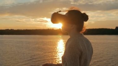 Sanal gerçeklik gözlükle cruise gemi güvertesinde günbatımında kadın