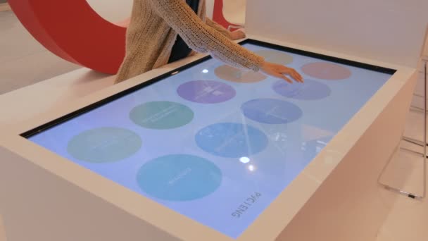 Vrouw met behulp van interactieve touchscreen display tafel op stedelijk tentoonstelling — Stockvideo