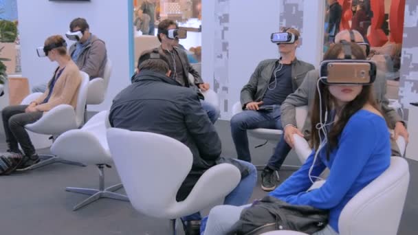 テクノロジーショーで仮想現実ヘッドセットを使用している人々のグループ — ストック動画