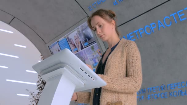 Femme utilisant l'affichage tactile interactif à l'exposition urbaine — Video