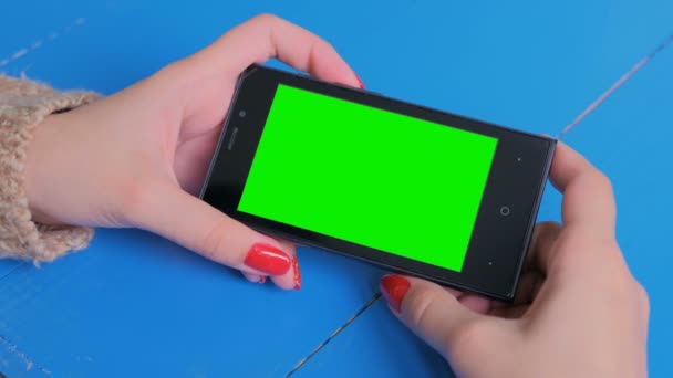 Woman looking at smartphone with green screen — Stock Video