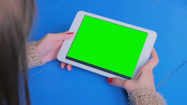 Vrouw op zoek naar tablet computer met groen scherm — Stockvideo