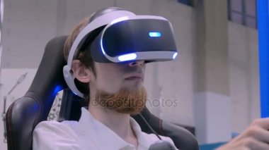 Sanal gerçeklik kulaklık kullanarak ve araba sürücü simülatörü oynayan genç adam