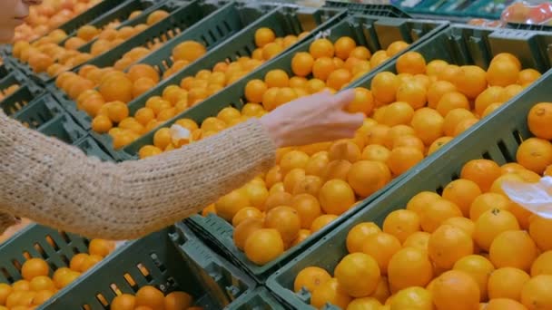 Mujer comprando mandarinas frescas en la tienda de comestibles — Vídeos de Stock