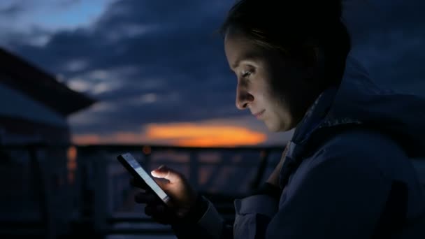 Žena používající vertikální smartphone na palubě výletní lodi v noci — Stock video