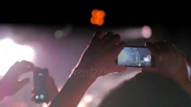 Akıllı telefonlu canlı müzik konserinin görüntülerini kaydeden eller.