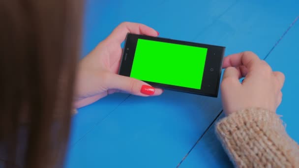 Woman using horizontal smartphone with green screen. Close up shot of woman's hands with mobile. Technology, chroma and internet concept — Stock Video