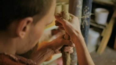 Profesyonel erkek çömlekçi işe kil hazırlıyor.