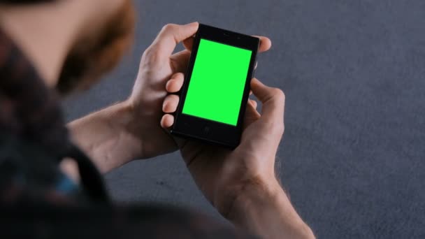 Άνδρας ψάχνει στο έξυπνο τηλέφωνο με πράσινη οθόνη — Αρχείο Βίντεο
