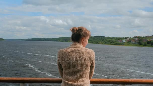 Young woman standing on deck of cruise ship and looking at river and landscape — Stock Video