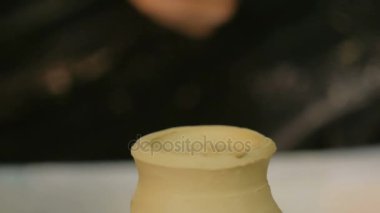 Çömlek atölyesinde özel bir aletle profesyonel çömlekçi şekillendirme kupası