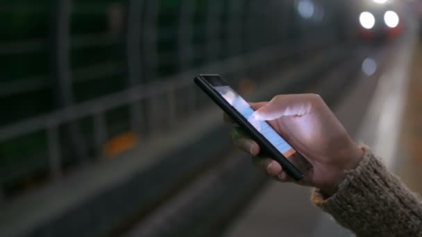 Woman using smartphone on subway platform — Stock Video