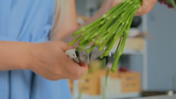 Professionelle Floristin schneidet Blütenstiele im Atelier — Stockvideo