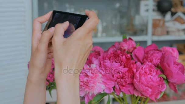 Mulher tirando foto de peônias rosa com smartphone . — Vídeo de Stock