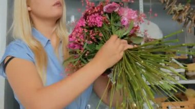 Çiçekçide düğün kompozisyonu hazırlayan profesyonel bir çiçekçi.