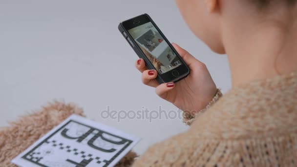 Woman using smartphone with augmented reality app, checking virtual house plan — Stock Video