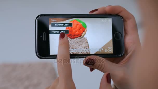 Женщина, использующая смартфон с приложением дополненной реальности и изучающая виртуальную модель — стоковое видео