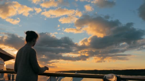 Mujer admirando la puesta de sol desde la cubierta del crucero — Vídeos de Stock