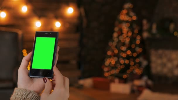 Vrouw op zoek naar smartphone met groen scherm — Stockvideo