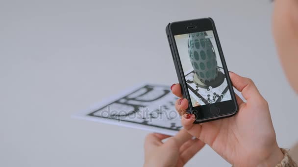Женщина использует смартфон с приложением дополненной реальности и размещает виртуальную модель — стоковое видео