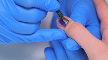 Kadın tırnak tırnak cilası uygulayarak profesyonel güzellik uzmanı