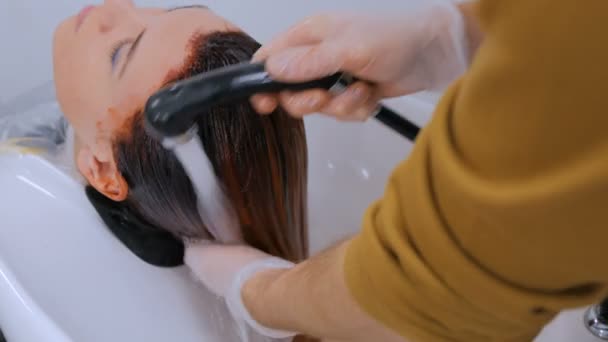 Hairdresser washing hair of woman client — Stock Video