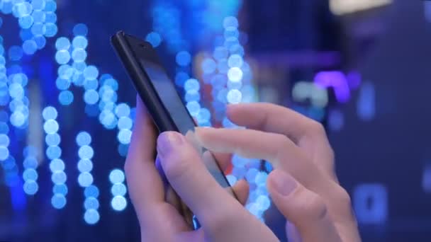 Mujer joven usando teléfono inteligente en la exposición de tecnología moderna — Vídeo de stock