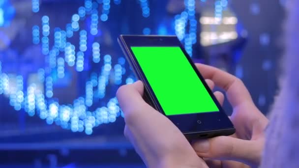 Woman looking at smartphone with green screen — Stock Video