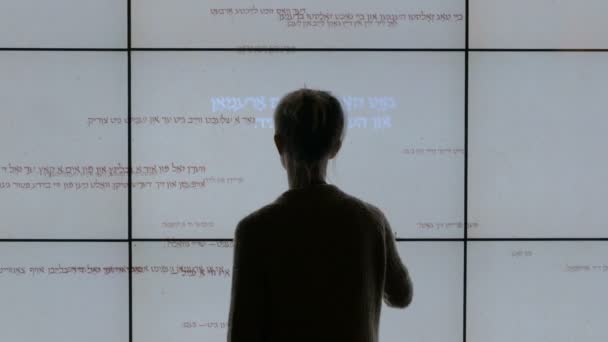 Woman using interactive touchscreen display at modern jewish history museum — Stock Video