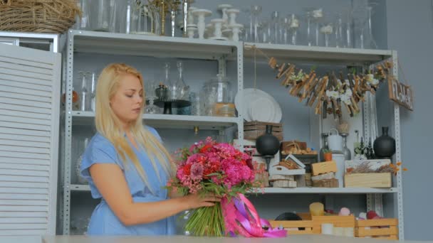 Floristería profesional sosteniendo y comprobando el ramo en el estudio — Vídeo de stock