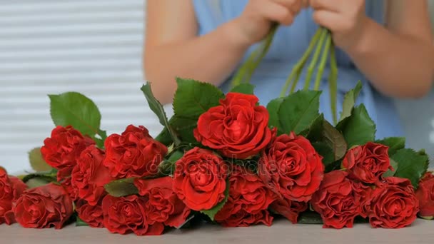 4 tiros. florista profissional preparar rosas vermelhas para buquê na oficina — Vídeo de Stock