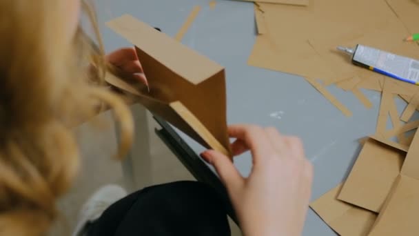 Профессиональная женщина-декоратор, дизайнер, работающая с крафт-бумагой — стоковое видео