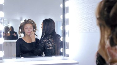 Sıvı ton temel uygulama kadının yüzünde makyaj sanatçısı