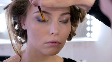 Profesyonel makyöz göz farı kullanıyor.