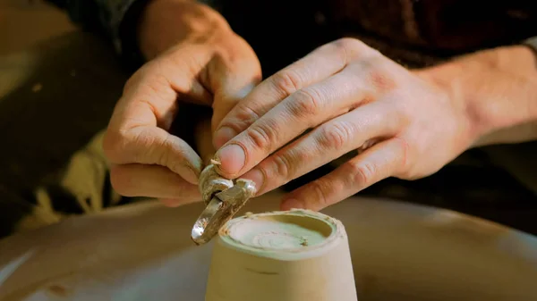 Professionele pottenbakker gesneden mok met speciaal gereedschap in aardewerk werkplaats — Stockfoto