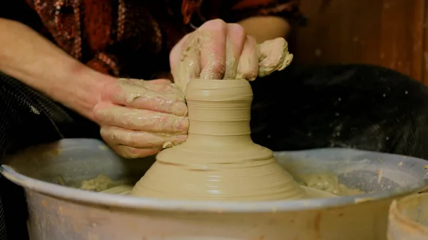 Professional male potter making ceramics in workshop