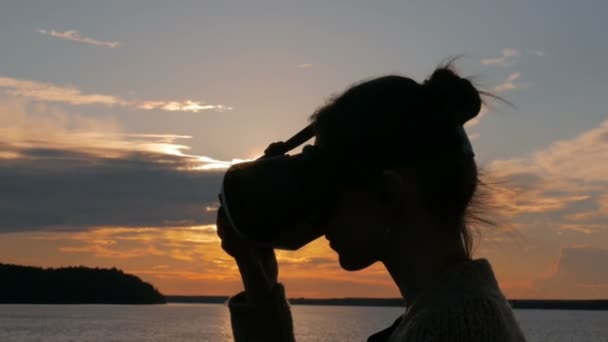 Mujer usando gafas de realidad virtual en la cubierta del crucero al atardecer — Vídeos de Stock