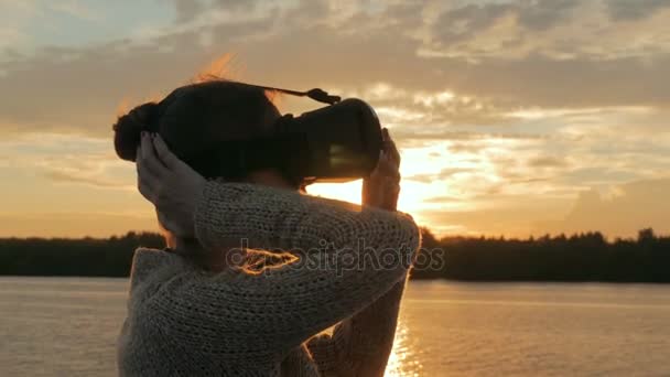 Vrouw met behulp van virtual reality bril op het dek van het cruiseschip bij zonsondergang — Stockvideo