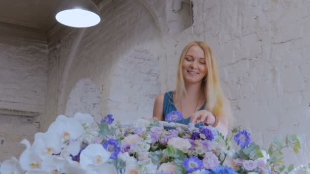 Florist macht großen Blumenkorb mit Blumen im Blumenladen — Stockvideo