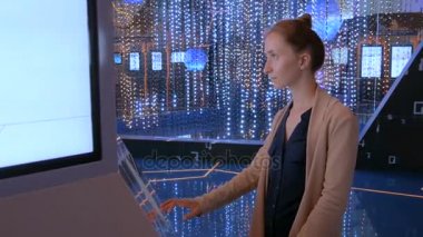 Modern teknoloji sergisinde etkileşimli dokunmatik ekran kullanan kadın