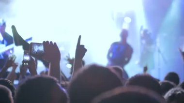 Akıllı telefonlu canlı müzik konserinin görüntülerini kaydeden eller.
