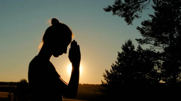 O femeie sportivă se roagă în parc la apusul soarelui — Fotografie, imagine de stoc