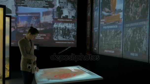 Женщина с интерактивным сенсорным экраном в музее современной истории — стоковое видео