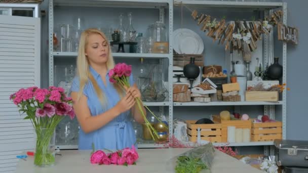 プロのフラワー アーティストがスタジオで花を並べ替え — ストック動画