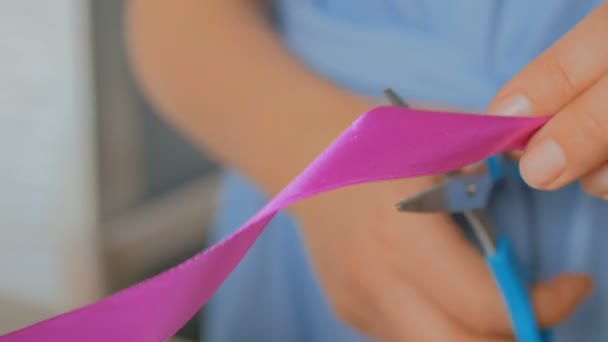 Close-up shot van vrouw snijden lint van bruiloft boeket op workshop — Stockvideo