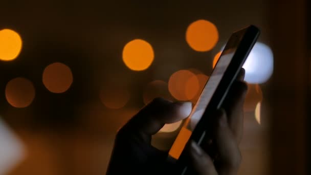 Mujer usando teléfono inteligente negro vertical por la noche — Vídeos de Stock