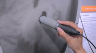 Mıknatıs sopalı kadın demir kum parçacıklarını kontrol ediyor