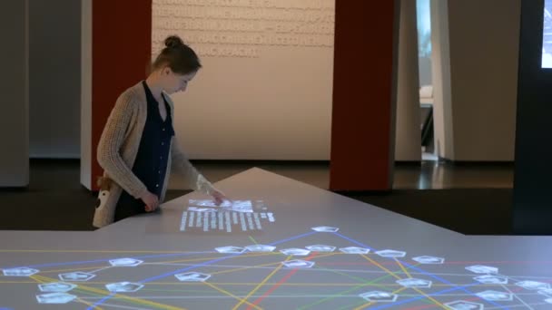 Woman using interactive touchscreen display at modern history museum — Stock Video